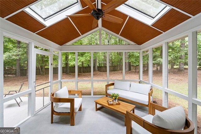 sunroom / solarium featuring a skylight, outdoor lounge area, a ceiling fan, and lofted ceiling