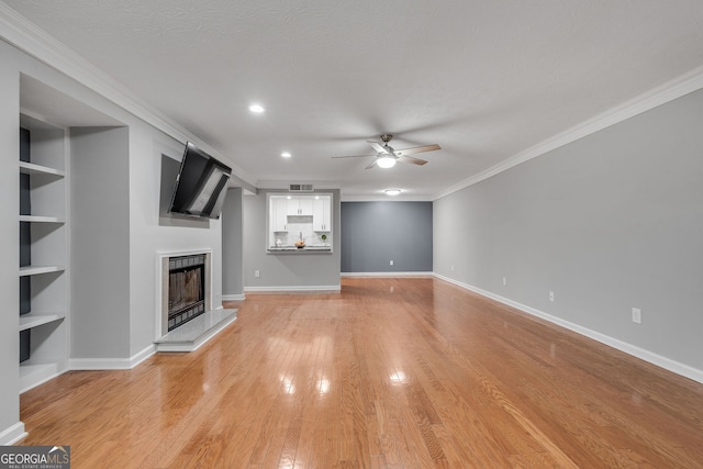 1015 Dunbar Dr, Dunwoody, GA 30338 - unfurnished living room with a ceiling fan, crown molding, a fireplace with raised hearth, light wood-style floors, and baseboards