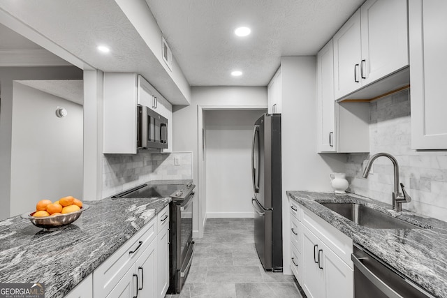 1015 Dunbar Dr, Dunwoody, GA 30338 - kitchen featuring appliances with stainless steel finishes, a textured ceiling, recessed lighting, white cabinetry, and backsplash