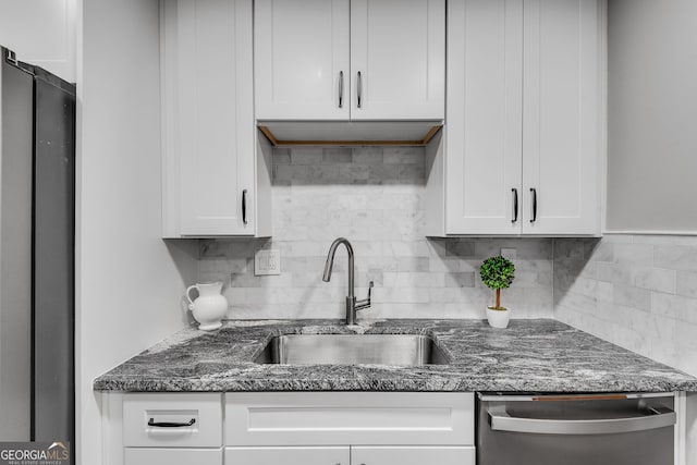 1015 Dunbar Dr, Dunwoody, GA 30338 - kitchen with stainless steel appliances, white cabinetry, backsplash, and dark stone countertops