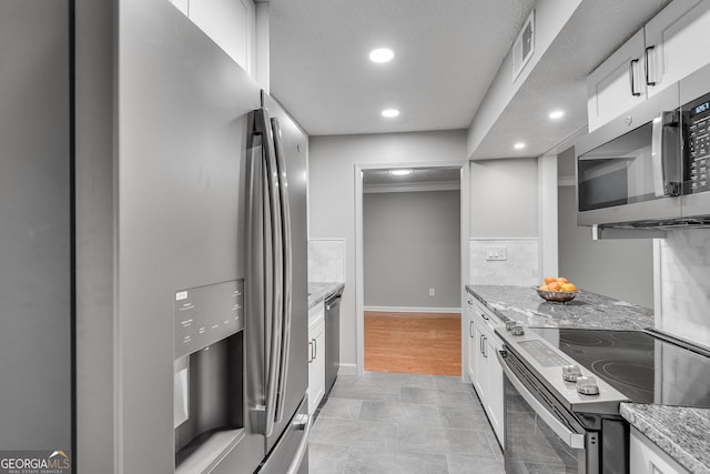 1015 Dunbar Dr, Dunwoody, GA 30338 - kitchen featuring stainless steel appliances, recessed lighting, white cabinetry, and light stone counters