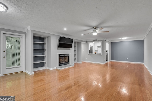 1015 Dunbar Dr, Dunwoody, GA 30338 - living room with light wood-type flooring, ceiling fan, crown molding, baseboards, and a textured ceiling