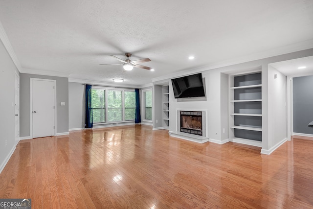 1015 Dunbar Dr, Dunwoody, GA 30338 - living area with crown molding, light wood-type flooring, a fireplace with raised hearth, built in shelves, and ceiling fan