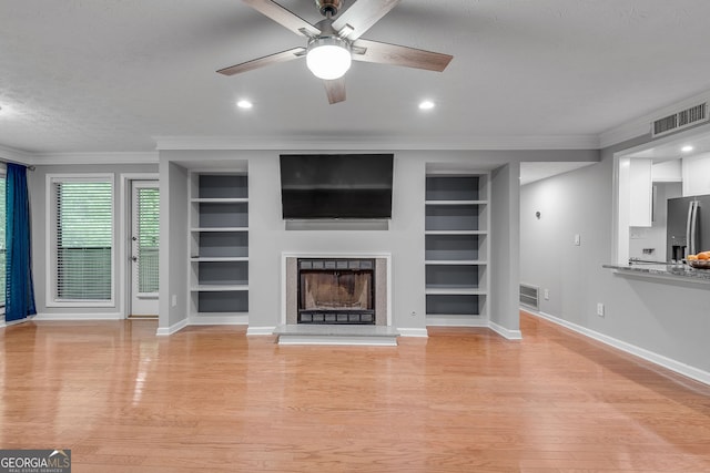 1015 Dunbar Dr, Dunwoody, GA 30338 - unfurnished living room with ceiling fan, ornamental molding, built in shelves, baseboards, and a textured ceiling