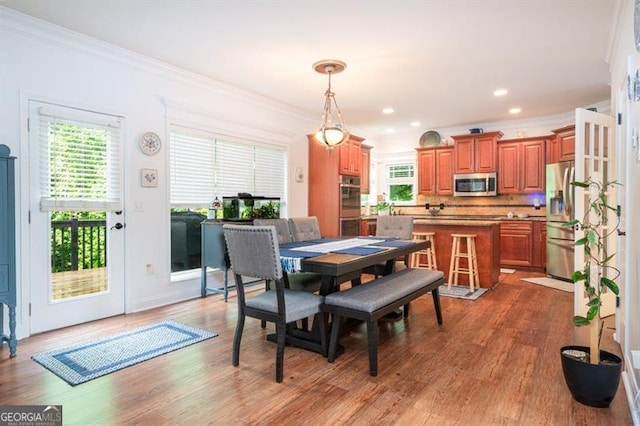 dining space featuring crown molding and wood finished floors