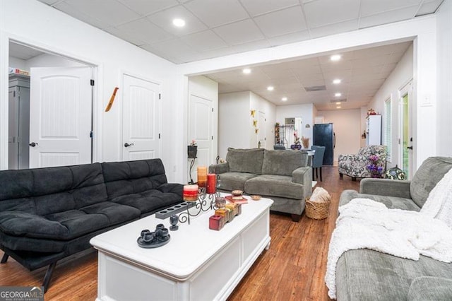living room featuring wood finished floors, a drop ceiling, and recessed lighting