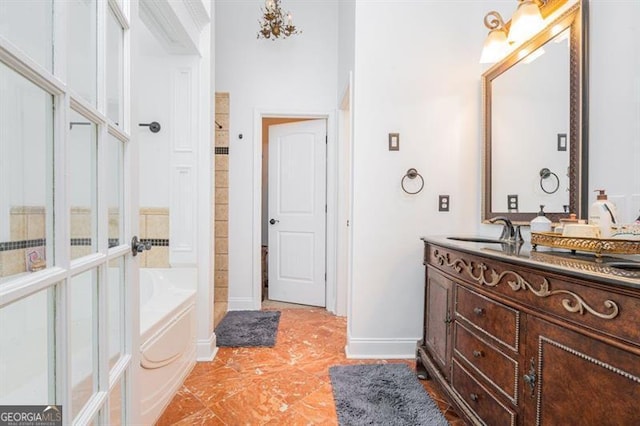 bathroom with a garden tub, baseboards, vanity, and tile patterned floors