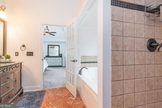 bathroom with french doors, a garden tub, crown molding, vanity, and baseboards