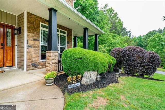 view of side of property with stone siding, a porch, and a yard