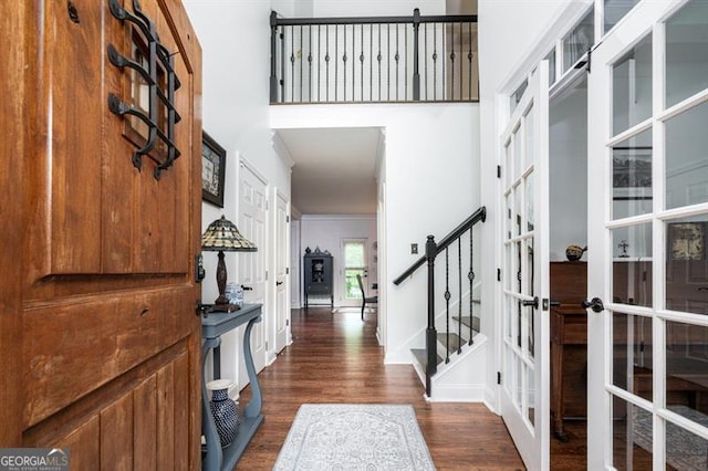 foyer entrance with french doors, dark wood-style flooring, stairs, and baseboards