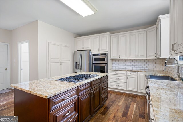 5034 Kingsbridge Pass, Powder Springs, GA 30127 - kitchen with stainless steel appliances, dark wood-type flooring, white cabinetry, a sink, and backsplash