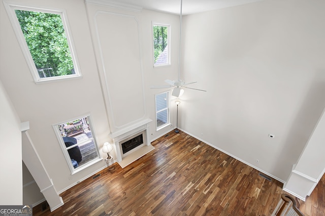 5034 Kingsbridge Pass, Powder Springs, GA 30127 - unfurnished living room featuring wood finished floors, a fireplace with flush hearth, ceiling fan, and baseboards