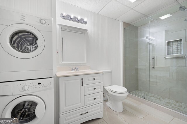 5034 Kingsbridge Pass, Powder Springs, GA 30127 - full bath featuring stacked washer / dryer, a stall shower, toilet, tile patterned flooring, and vanity