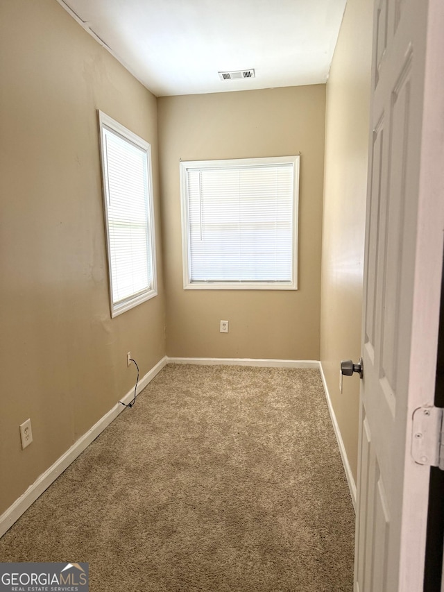 empty room featuring carpet flooring and baseboards