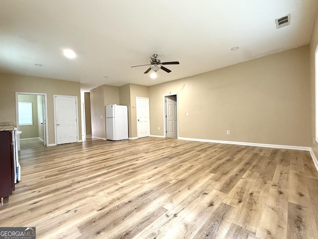 unfurnished living room featuring a ceiling fan, baseboards, light wood-style flooring, and recessed lighting