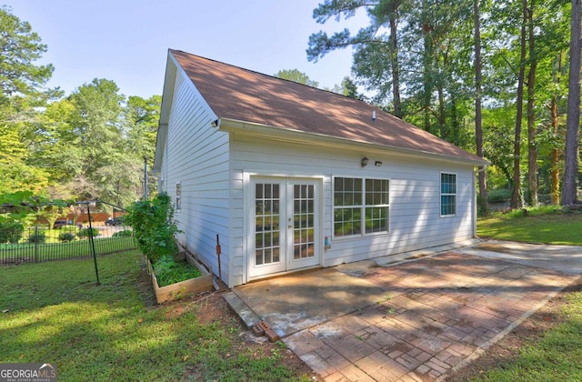 back of house featuring a patio and roof with shingles