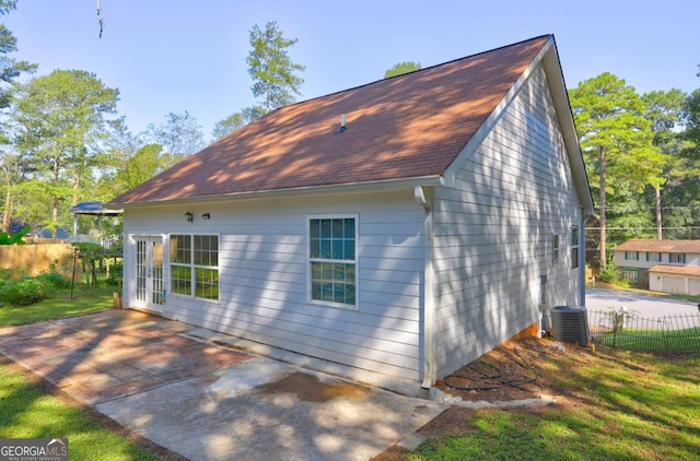 view of side of home with fence, a patio area, and cooling unit