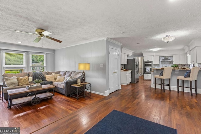 3441 Sherrod Dr SW, Marietta, GA 30060 - living room featuring dark wood finished floors, a textured ceiling, a ceiling fan, baseboards, and crown molding