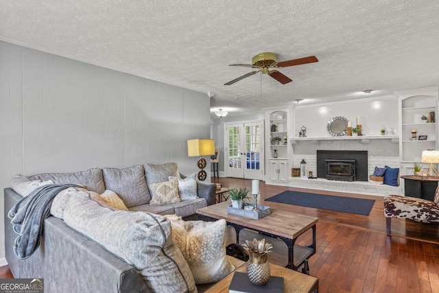 3441 Sherrod Dr SW, Marietta, GA 30060 - living area with ceiling fan, wood-type flooring, a textured ceiling, a fireplace, and french doors