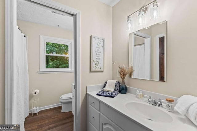 3441 Sherrod Dr SW, Marietta, GA 30060 - bathroom featuring wood finished floors, vanity, toilet, and baseboards