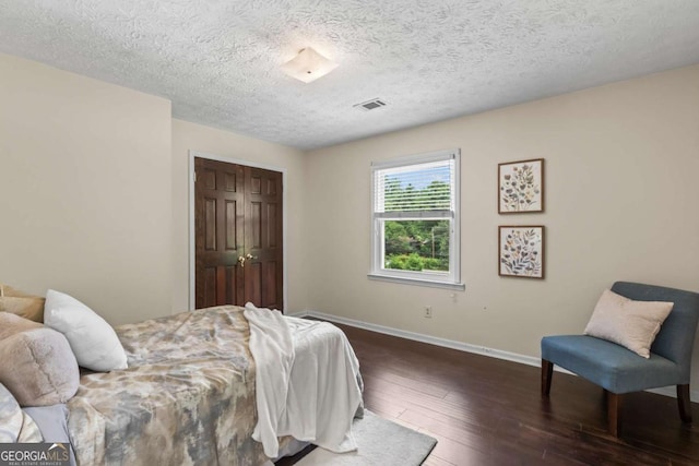 3441 Sherrod Dr SW, Marietta, GA 30060 - bedroom with dark wood-style flooring, baseboards, a textured ceiling, and a closet