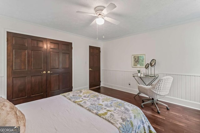 3441 Sherrod Dr SW, Marietta, GA 30060 - bedroom with dark wood-style floors, a wainscoted wall, a closet, crown molding, and a ceiling fan