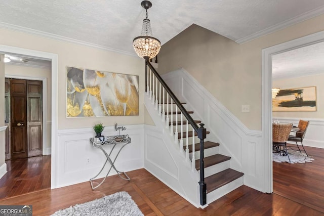 3441 Sherrod Dr SW, Marietta, GA 30060 - staircase featuring a chandelier, hardwood / wood-style floors, a decorative wall, a wainscoted wall, and ornamental molding