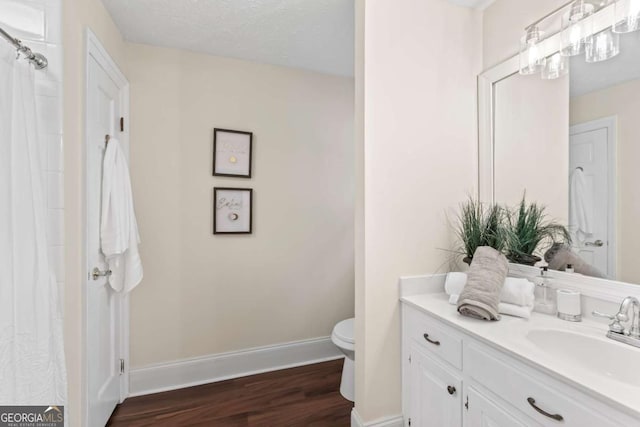 3441 Sherrod Dr SW, Marietta, GA 30060 - bathroom with wood finished floors, toilet, baseboards, and vanity