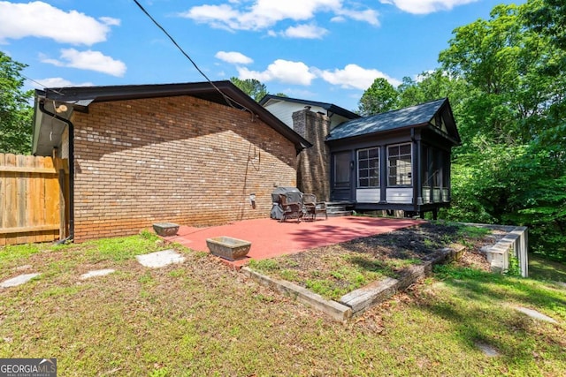 3441 Sherrod Dr SW, Marietta, GA 30060 - back of property featuring a sunroom, a patio area, and brick siding