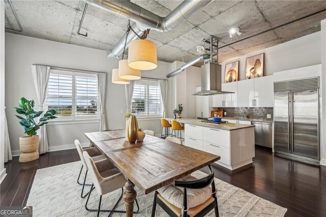 206 NE 11th St NE Unit Ph703, Atlanta, GA 30309 - kitchen with stainless steel appliances, dark wood-style floors, a kitchen island, white cabinets, and decorative backsplash