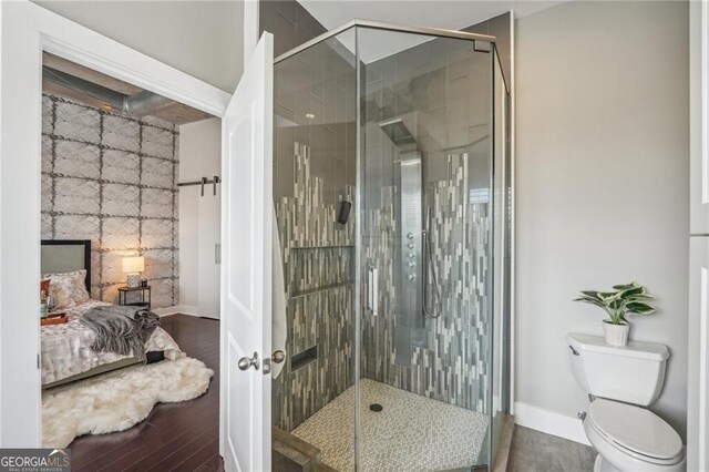 206 NE 11th St NE Unit Ph703, Atlanta, GA 30309 - bathroom with a stall shower, baseboards, wood finished floors, and toilet