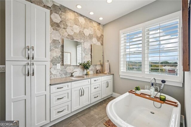 206 NE 11th St NE Unit Ph703, Atlanta, GA 30309 - bathroom featuring plenty of natural light, a soaking tub, double vanity, recessed lighting, and tasteful backsplash