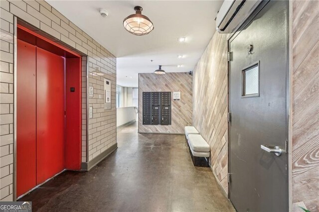 206 NE 11th St NE Unit Ph703, Atlanta, GA 30309 - corridor featuring elevator, a wall mounted air conditioner, finished concrete floors, wooden walls, and mail area