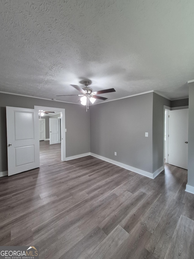 unfurnished living room featuring a ceiling fan, wood finished floors, baseboards, a textured ceiling, and crown molding