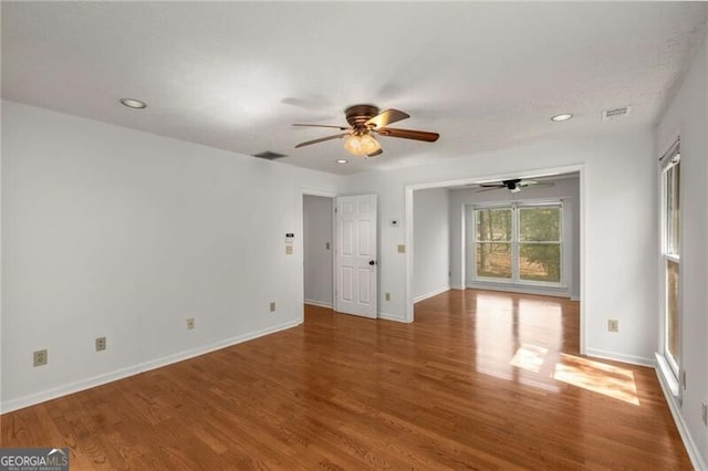 empty room featuring ceiling fan, wood finished floors, recessed lighting, and baseboards
