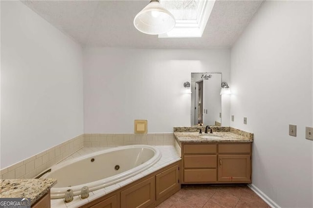 full bathroom with a skylight, a whirlpool tub, tile patterned floors, and vanity