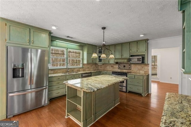 kitchen with green cabinets, stainless steel appliances, dark wood-style flooring, and a textured ceiling