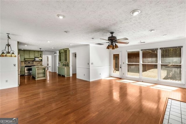 unfurnished living room with wood finished floors, a ceiling fan, a textured ceiling, baseboards, and recessed lighting