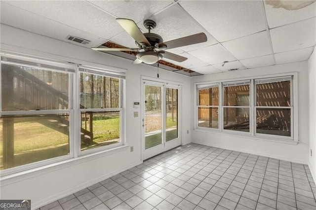 unfurnished sunroom with ceiling fan, tile patterned flooring, a paneled ceiling, and baseboards