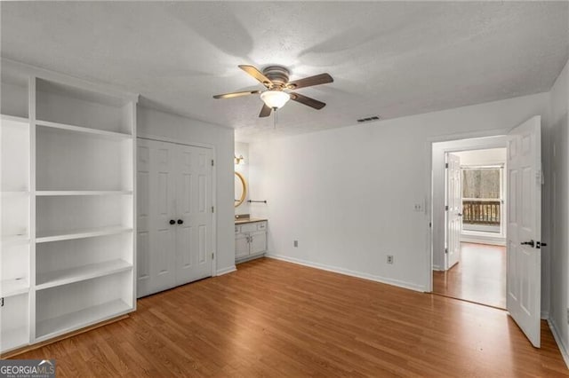 unfurnished bedroom featuring wood finished floors, baseboards, and ceiling fan