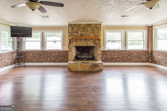 3842 Kay Cir, Blackshear, GA 31516 - unfurnished living room with a ceiling fan, baseboards, hardwood / wood-style flooring, a textured ceiling, and a fireplace