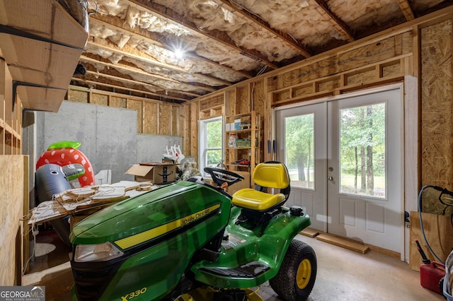 miscellaneous room featuring french doors and unfinished concrete floors
