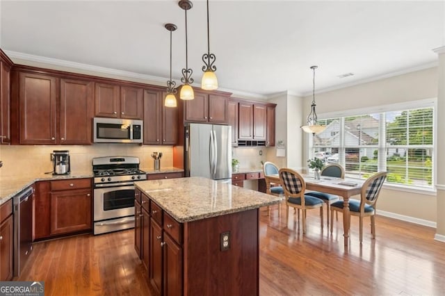 3365 Buffington Ln, Cumming, GA 30040 - kitchen with stainless steel appliances, crown molding, decorative backsplash, dark wood finished floors, and a center island