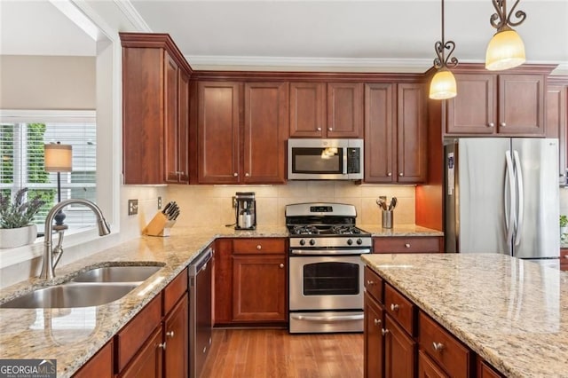 3365 Buffington Ln, Cumming, GA 30040 - kitchen featuring appliances with stainless steel finishes, a sink, light wood-type flooring, hanging light fixtures, and tasteful backsplash