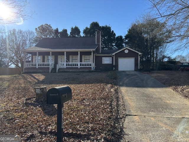 3709 Charlotte Dr, Rex, GA 30273 - view of front of house with a chimney, concrete driveway, an attached garage, and covered porch