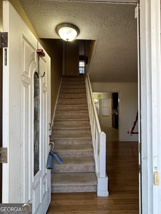 3709 Charlotte Dr, Rex, GA 30273 - staircase with wood finished floors and a textured ceiling