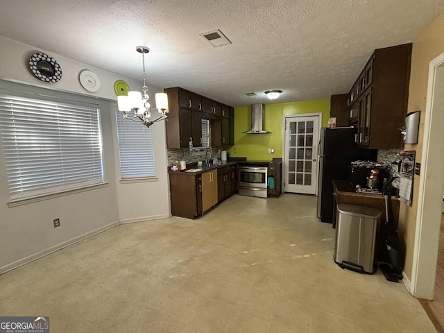 3709 Charlotte Dr, Rex, GA 30273 - kitchen featuring appliances with stainless steel finishes, a chandelier, wall chimney exhaust hood, dark brown cabinetry, and decorative backsplash