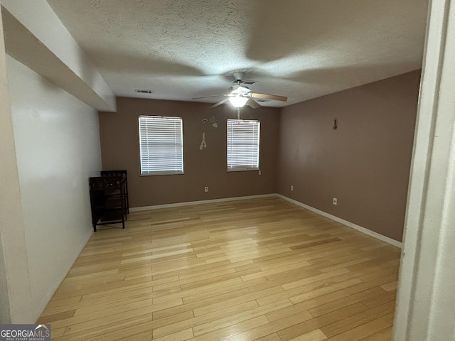 3709 Charlotte Dr, Rex, GA 30273 - empty room with ceiling fan, a textured ceiling, light wood-type flooring, and baseboards