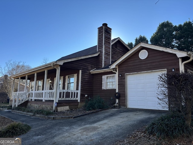 3709 Charlotte Dr, Rex, GA 30273 - view of front of home featuring covered porch, a garage, a chimney, and driveway