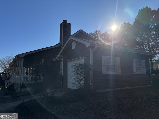 3709 Charlotte Dr, Rex, GA 30273 - view of side of home with a garage, a chimney, and driveway